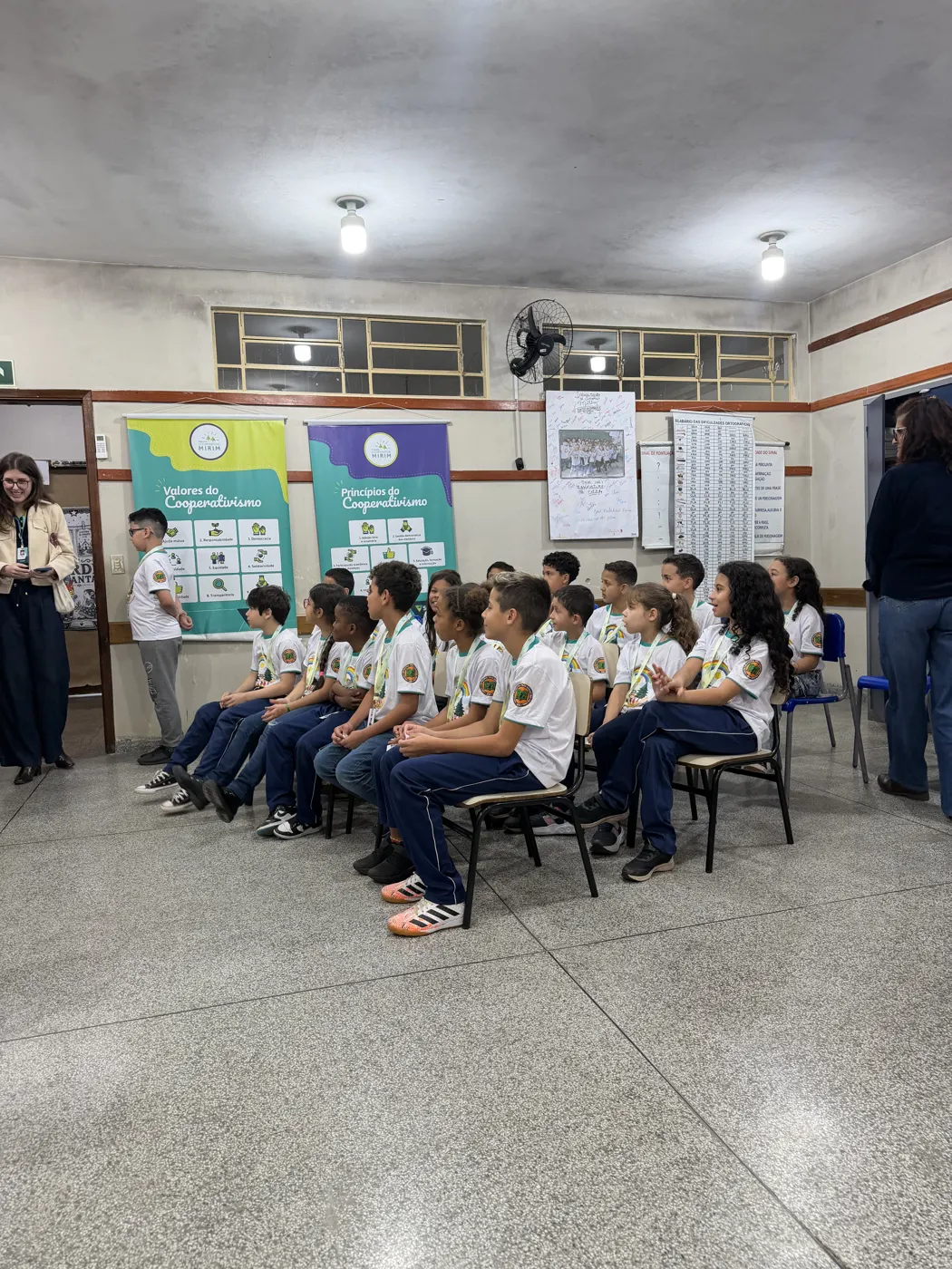 Sala de aula de uma escola que já tem cooperativa mirim, com alunos sentados em roda