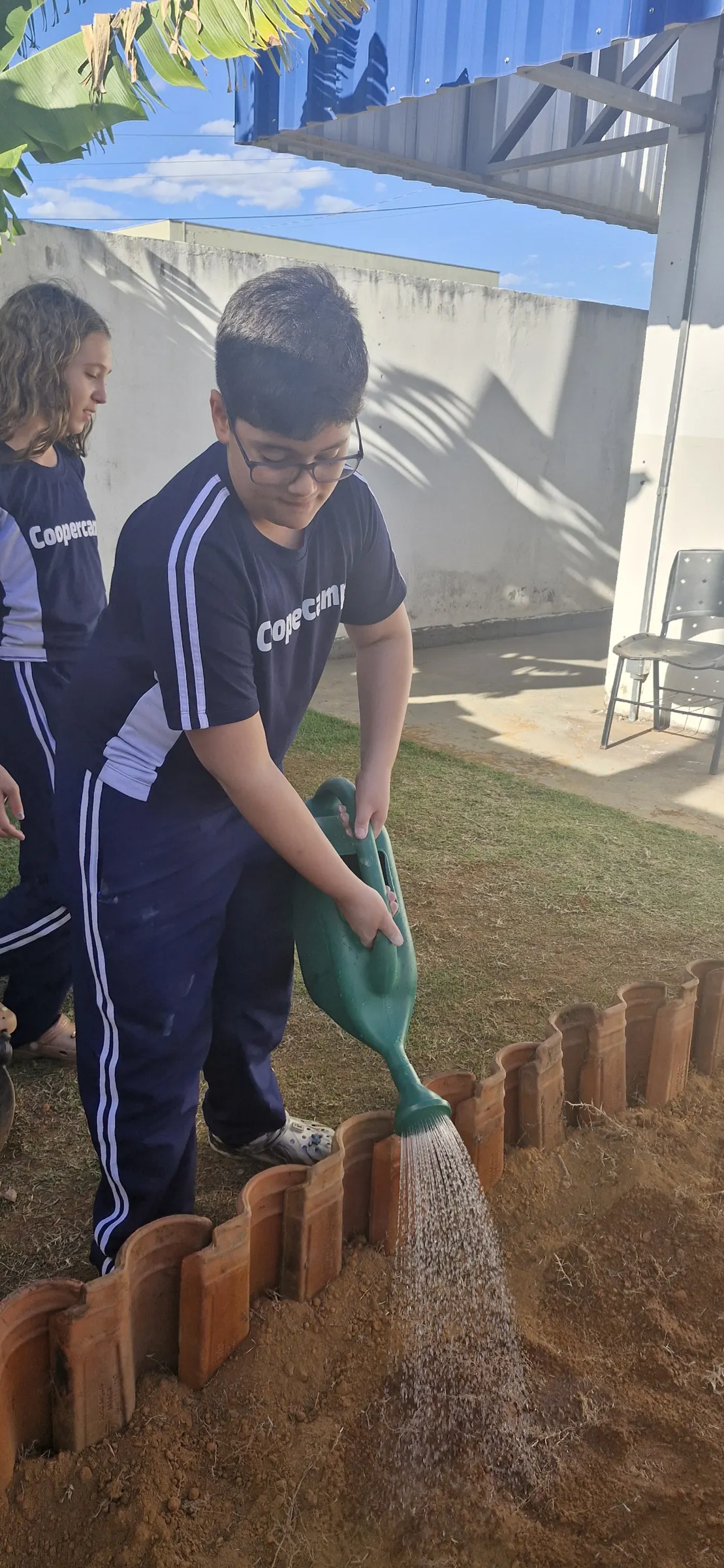 Aluna regando o canteiro